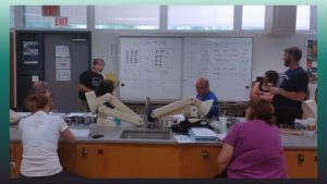 photo showing a group looking at a whiteboard full of results