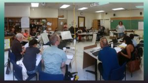 image showing a group of teachers in a circle in a classroom