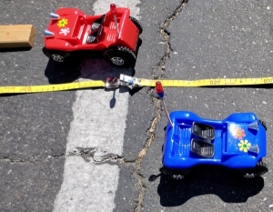 photos showing a blue buggy pointed to the right and a red buggy pointed to the left, with a tape measure between them